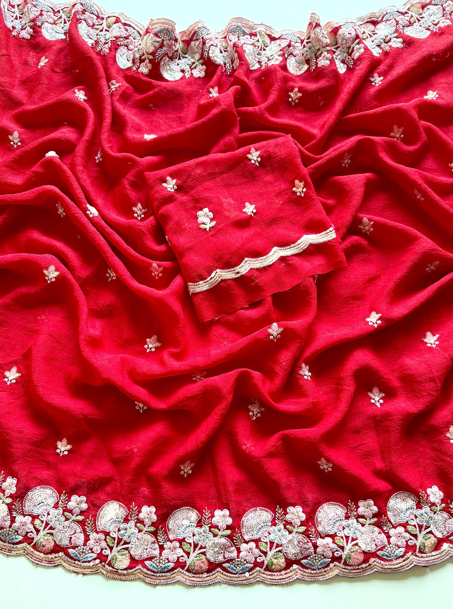 Red fabric with intricate white embroidery on a white background-Soft crush silk saree with multicolor sequin embroidery
