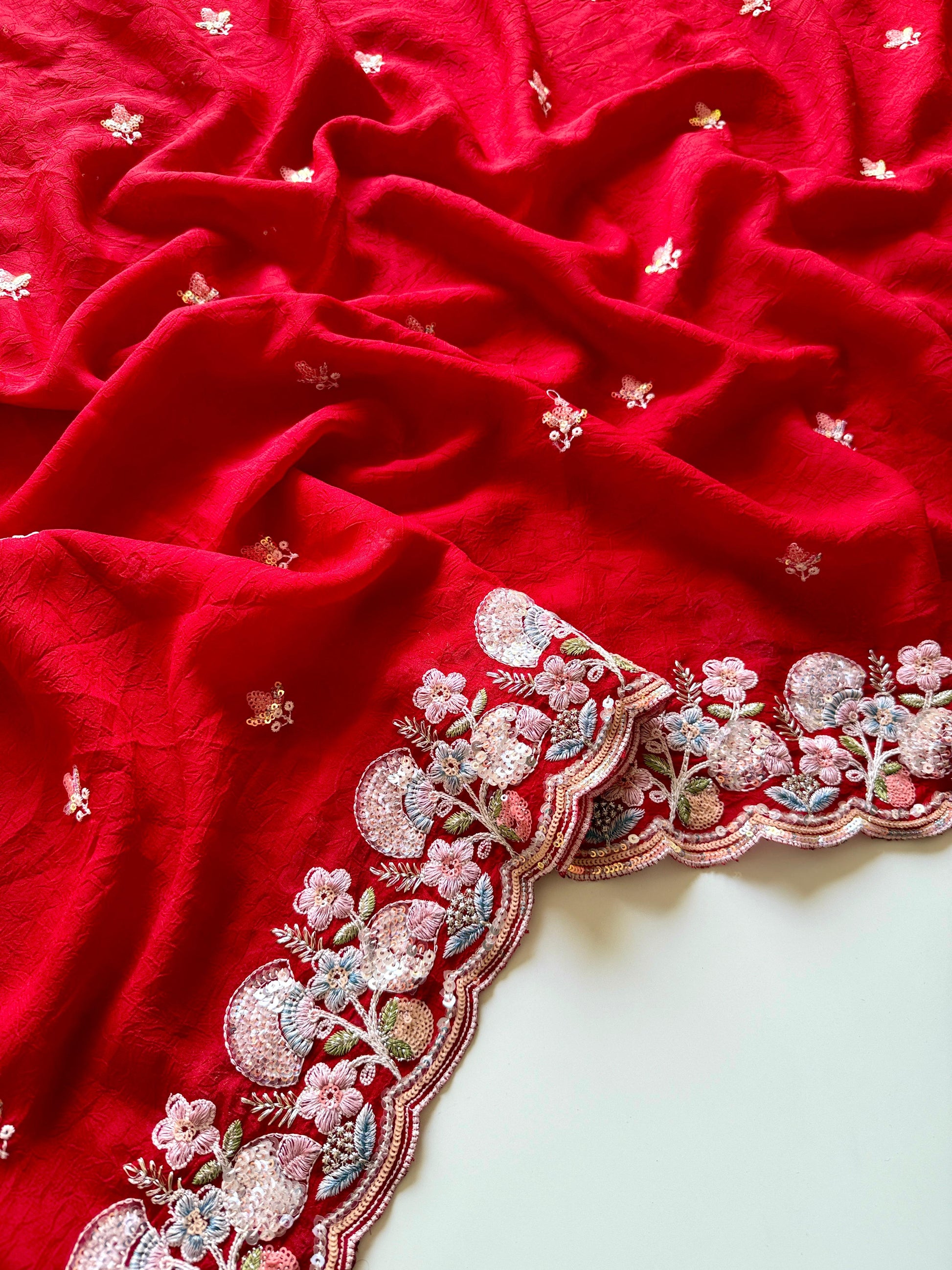 Soft crush silk saree with multicolor sequin embroidery and blouse-Red fabric with intricate floral embroidery on a white background