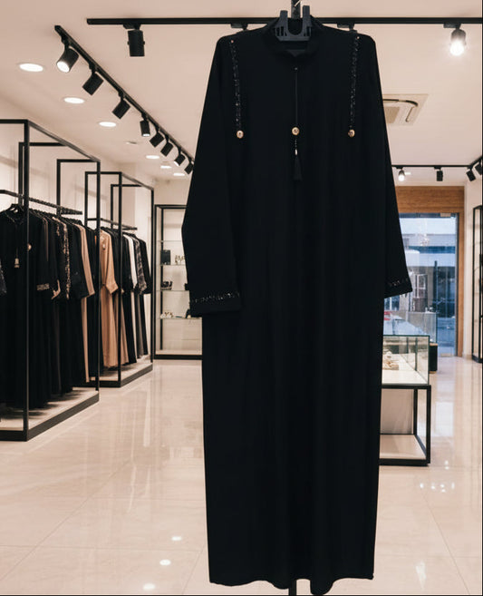 Elegant black abaya with decorative strap detail and tassel front design