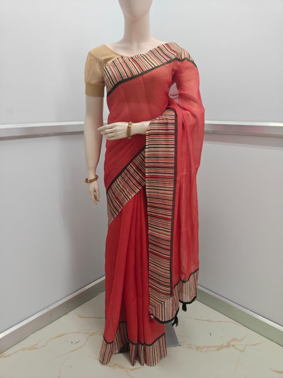 Red saree with black and gold border on a mannequin against a white background-Lightweight Linen Cotton Saree for office and daily wear – soft breathable fabric