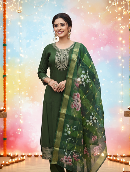 Woman wearing a green traditional outfit with floral patterns against a festive background.