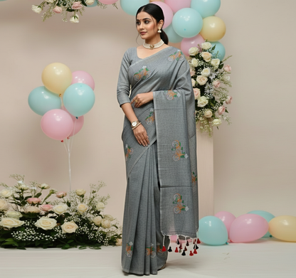 Woman in a gray saree with floral decorations and balloons in the background